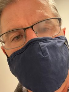 picture of a person with a mask and one fogged eye glass lens