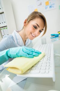 woman wiping a computer keyboard