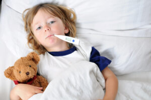photo of sick child with thermometer in mouth